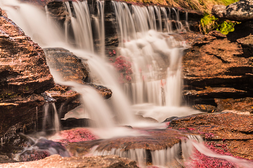 Long exposure of a waterfall, blurred motion of water cascading onto rocks in North West England, UK.