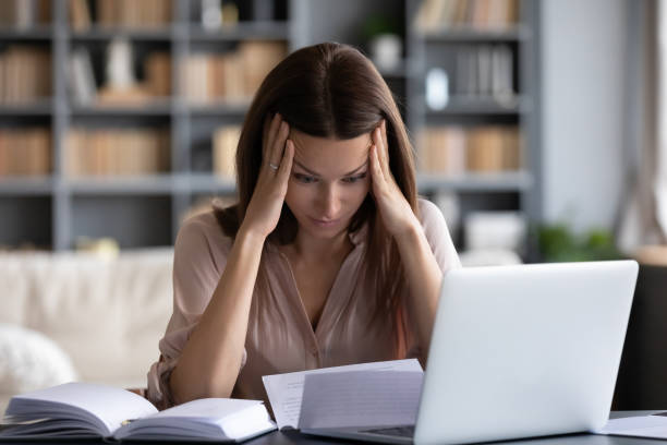 istock Stressed young woman holding head in hands, feeling desperate. 1217463756