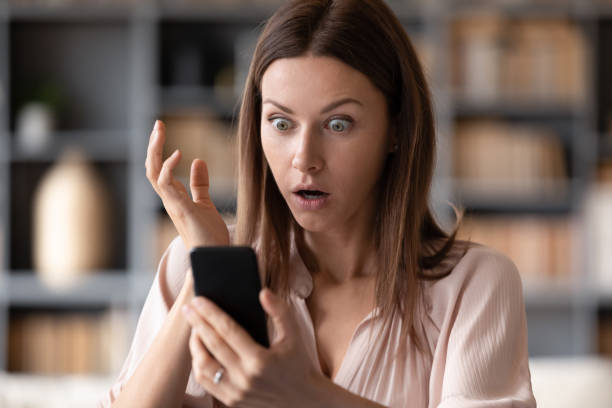 close up young shocked woman looking at mobile phone screen. - smart phone text messaging mobile phone telephone imagens e fotografias de stock