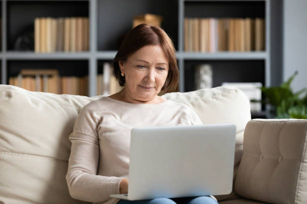 istock Concentrated pleasant mature older woman looking at computer screen. 1217463837