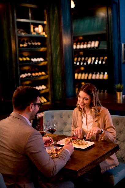 istock Young couple having a dinner in the restaurant and drinking red wine 1217463972