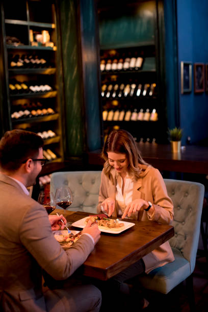 istock Young couple having a dinner in the restaurant and drinking red wine 1217463978