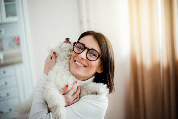 istock Young woman working from home and playing with her dog 1217464105