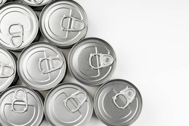 vista superior de varias latas de alimentos almacenadas en casa sobre fondo blanco - non perishable fotografías e imágenes de stock