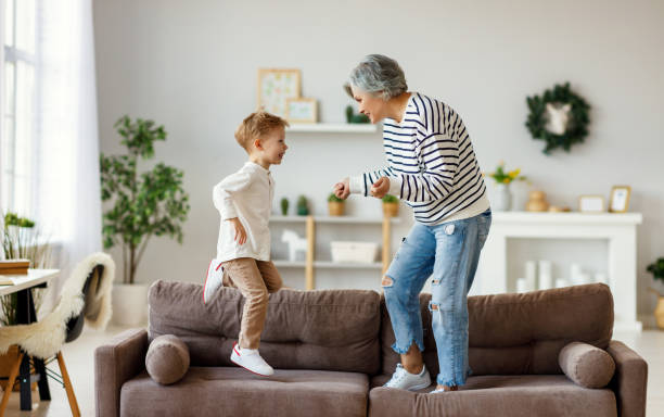 istock Grandmother and grandson dancing on sofa 1217472623