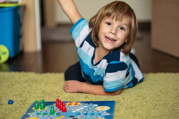 istock Happy boy is winning in board game 1217473342
