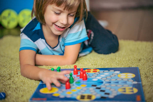 istock Smiling boy is playing board game on the floor 1217473492