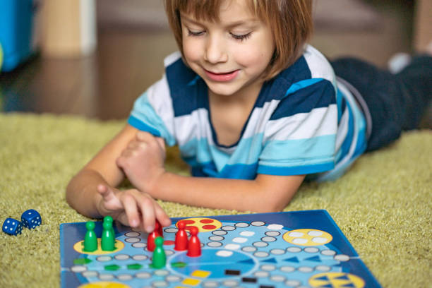istock Close up boy is playing board game on the floor 1217473619
