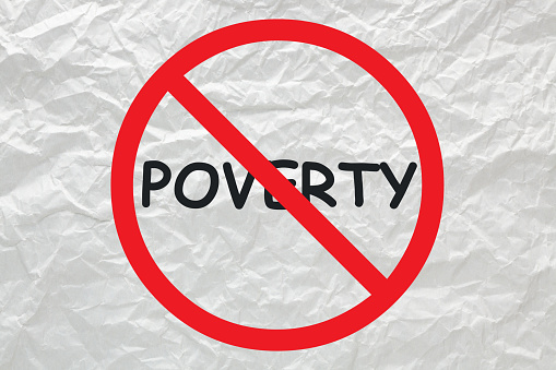 Poverty stop sign on white crumpled paper.