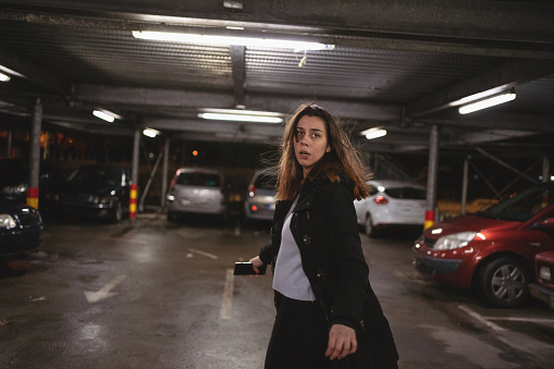 Terrified woman walking on a parking lot