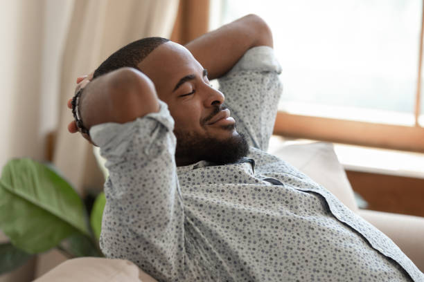 istock African guy closed eyes resting on couch thinking feels satisfied 1217477760