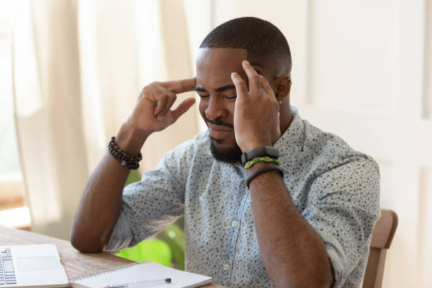 istock African overworked man suffers from migraine severe headache 1217477790
