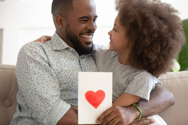istock African father received from daughter postcard cuddles her showing gratitude 1217477817