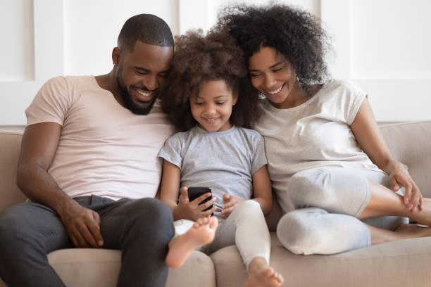 istock African family sitting on couch having fun using smartphone apps 1217477835