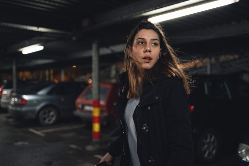 Terrified woman walking on a parking lot