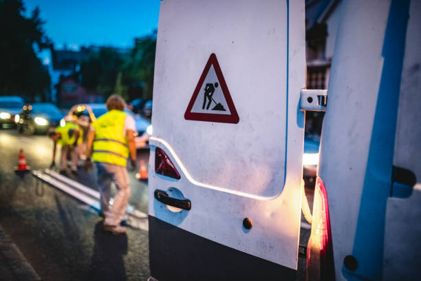 central european road crew neu lackiert straßenmarkierungen bei dämmerung - construction safety mid adult men road construction stock-fotos und bilder