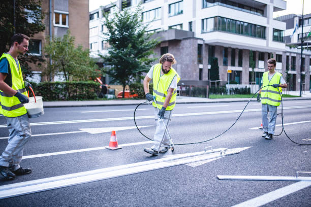 Arrow Marking Spray Painting Upgrade in Urban Environment Construction crew members carefully spray painting arrow marking on urban street in Central Europe capital city. freshly painted road markings stock pictures, royalty-free photos & images