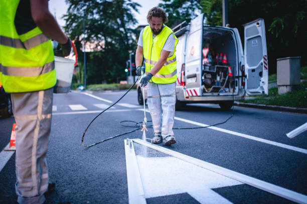 istock Urban Construction Crew Spray Painting Arrow Marking at Dusk 1217480502