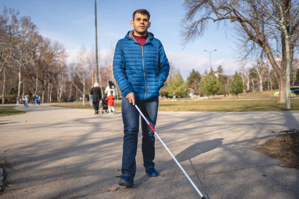 istock Confident blind man walking at a park with a blind persons cane 1217483070