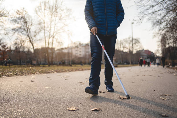 istock Blind person walking with a cane at a park 1217483157