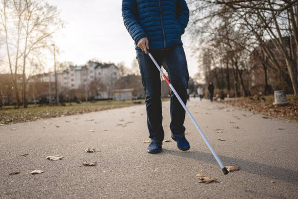istock Unrecognizable blind person walking with a cane in a park 1217484096