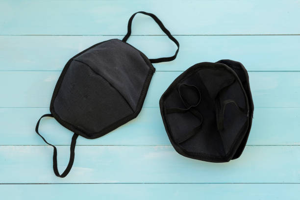 istock Black face masks on a blue wooden background top view. 1217487298