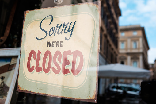 “Sorry we’re closed” door sign board on shop window, abandoned shut down cafe, closed restaurant business, Coronavirus COVID-19 viruse disease global pandemic crisis, quarantine isolation lockdown concept