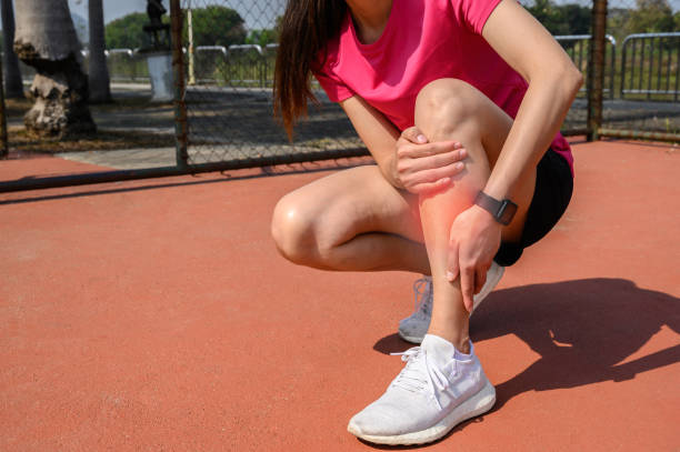 colpo ritagliato di donna runner che soffre di dolore per la stecca shin. accade spesso nella parte anteriore o interna della parte inferiore della gamba dall'allenamento in modo troppo. - stinco gamba umana foto e immagini stock