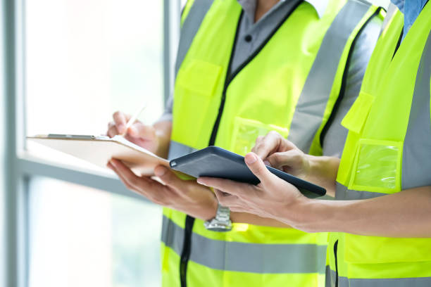 istock Two engineers man standing in front of windows and used tablet to find construction model 1217504668