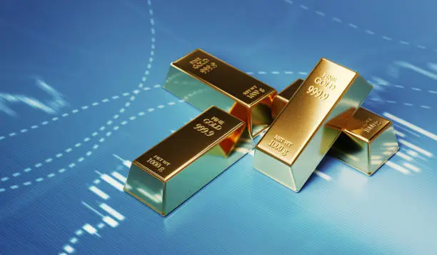 Gold bars sitting in front of bar graph. Selective focus. Horizontal composition with copy space. Stock market and finance concept.
