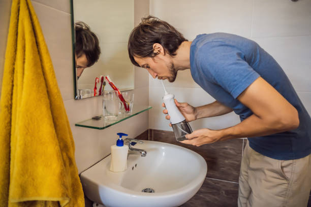 istock A man uses an oral irrigator in his bathroom 1217508388