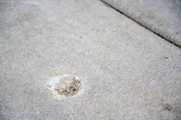 Photo of Filled in mud jacking drilled holes in concrete pavement