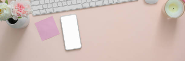 istock Top view of creative workspace with blank screen smartphone on pink table 1217513593