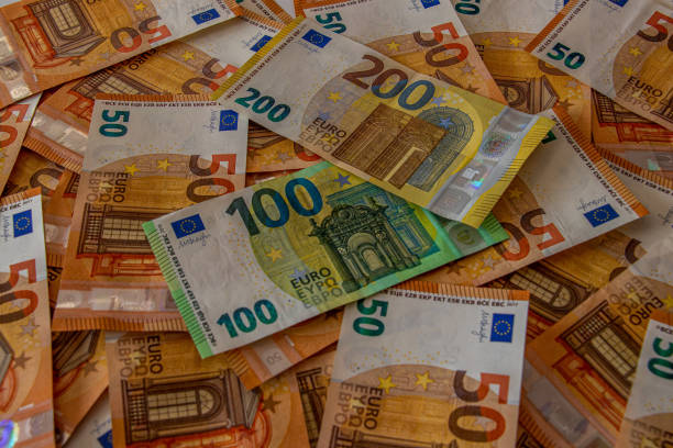 istock 50, 100 euro bills laying on table 1217521594
