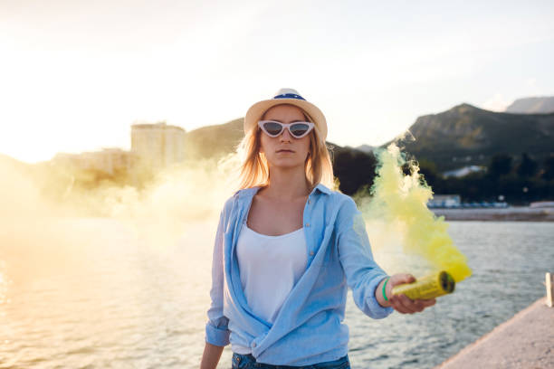 istock Woman having fun with smoke bomb on the beach 1217528836