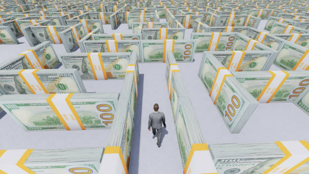 Businessman looking for a way out of the Money Maze made of one hundred usd banknotes. stock photo