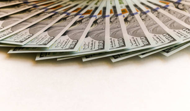 istock A fan of hundred-dollar bills on a light background. 1217531463
