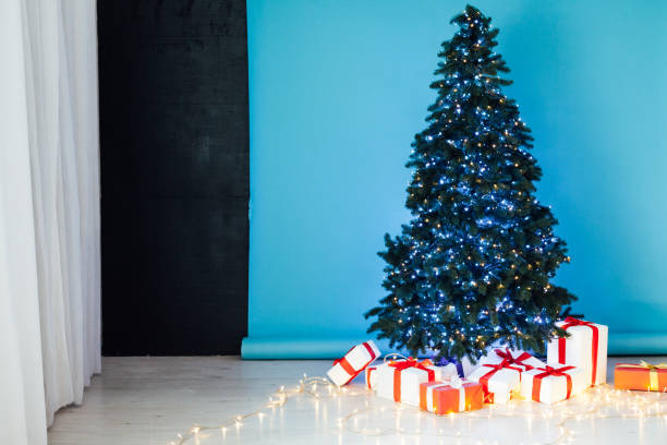 istock blue lights garlands Christmas tree with New Year's gifts 1217536016