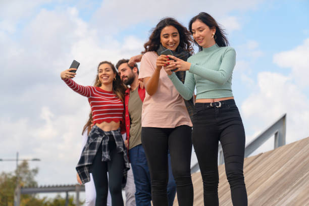 istock Group of cheerful friends using mobile phones and sharing 1217538855
