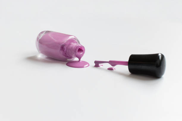istock Dripping pink nail polish bottle next to applicator brush 1217538868