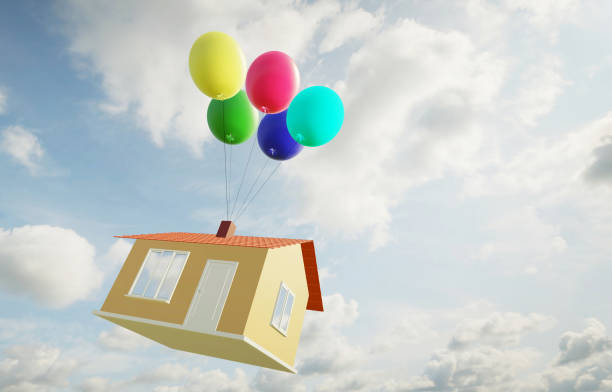 istock Small house flies high in the sky in balloons 1217540077