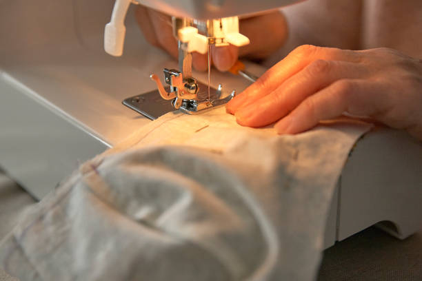 istock Detail shot of hands sewing a face mask . 1217543778