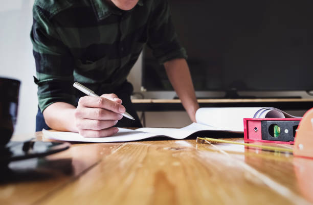 istock Engineer are planning to drawing house structure on Blueprint for his customers. 1217546247