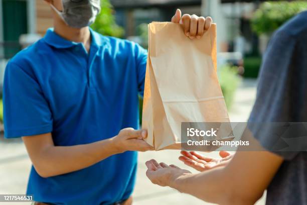 Close Up Asian Delivery Man Wearing Mask Send Food From Restaurant Protection Pandemic And Fever On Front Receiver Shipping Deliver Cargo Social Distancing While The Virus Is Spreading Stock Photo - Download Image Now