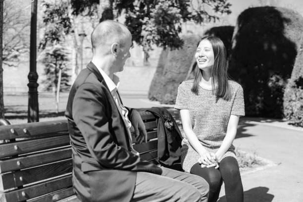 istock Multiethnic couple on a park bench 1217550250