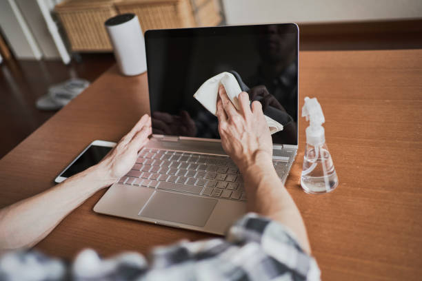 istock Man disinfects laptop with alcohol at home 1217551722
