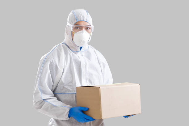 istock Asian man in protective suit with box in hands 1217552135
