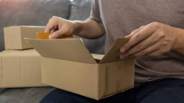 istock Startup small business entrepreneur SME, young asian man working with laptop computer and delivery packaging box, online market packing, SME e-commerce seller concept
