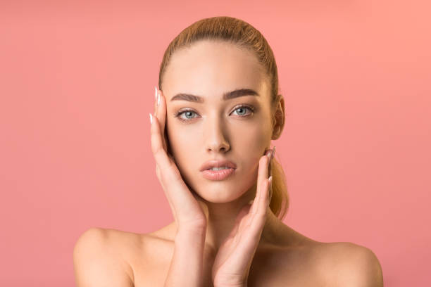 istock Sensual Blonde Girl Touching Perfect Face Posing In Studio 1217556013