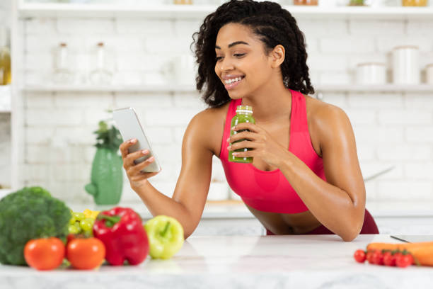 istock Black Girl Drinking Smoothie And Checking Social Media 1217556344